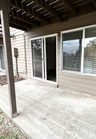 A patio with a sliding glass door and a brown pillar.