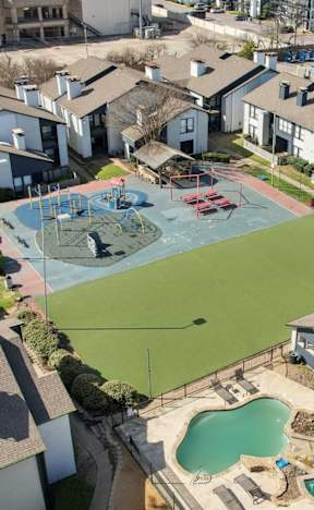 A bird's eye view of a neighborhood with a large swimming pool in the foreground.