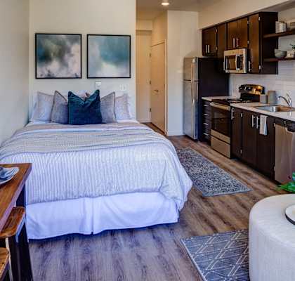 Living room with bed, tv at Commons at Sylvan Canyon Apartments, Portland, Oregon
