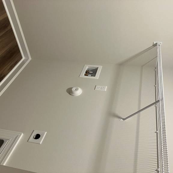 A white wall with a small square hole in the middle.