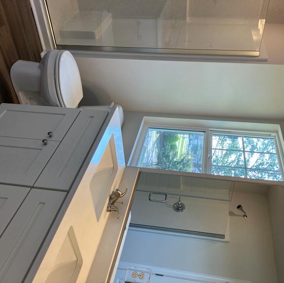 A bathroom with a skylight and a window.