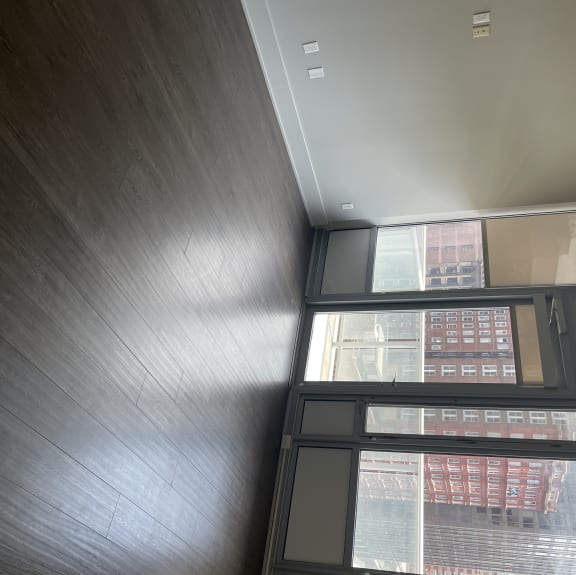 The living area is cozy and open with large windows and the balcony door.