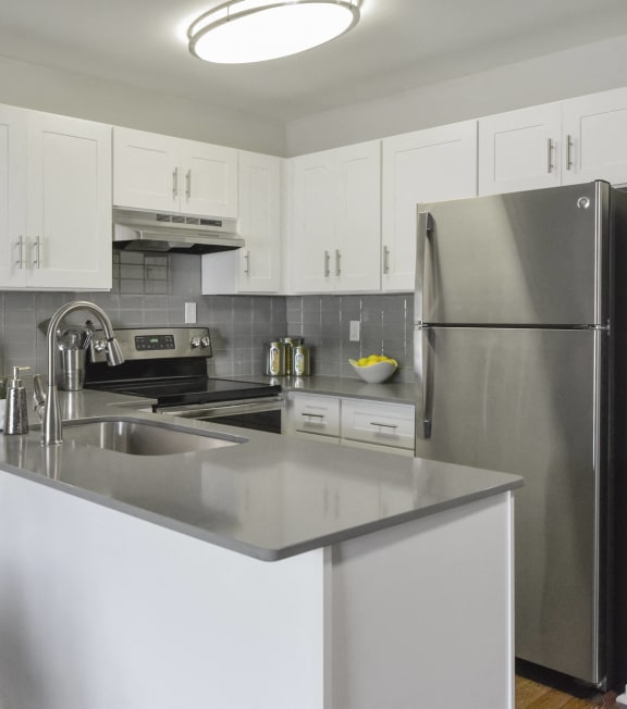 a kitchen with stainless steel appliances and white cabinets