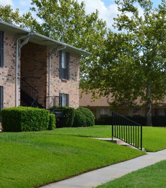 a leasing office sign in front of a brick apartment building at Archer Village Apartments,Sherman,