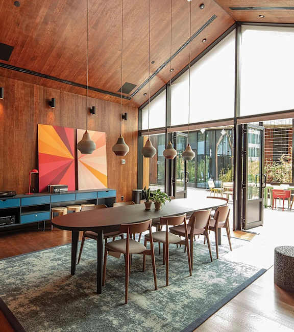 A modern dining room with a wooden table surrounded by chairs.