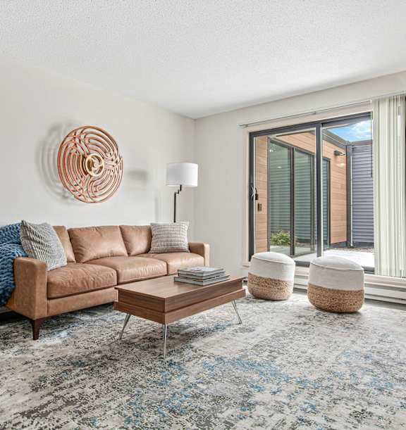Living room with a couch and table and a tv at The Bosk Apartment Homes, Woodbury