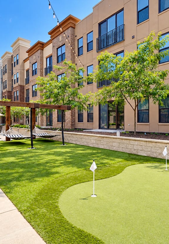 A view of a building with a green lawn in front.