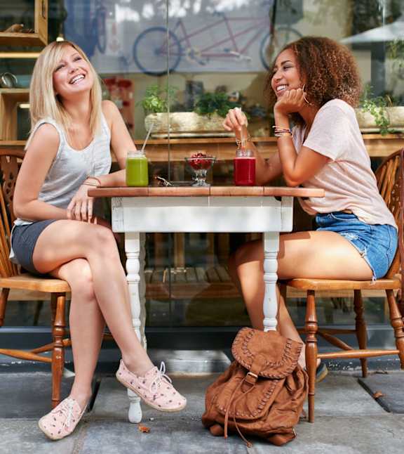 Two women sitting and having juice at Ansley at Town Center Apartments, Georgia