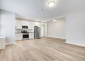 Thumbnail 5 of 22 - a renovated living room and kitchen with white walls and wood flooring