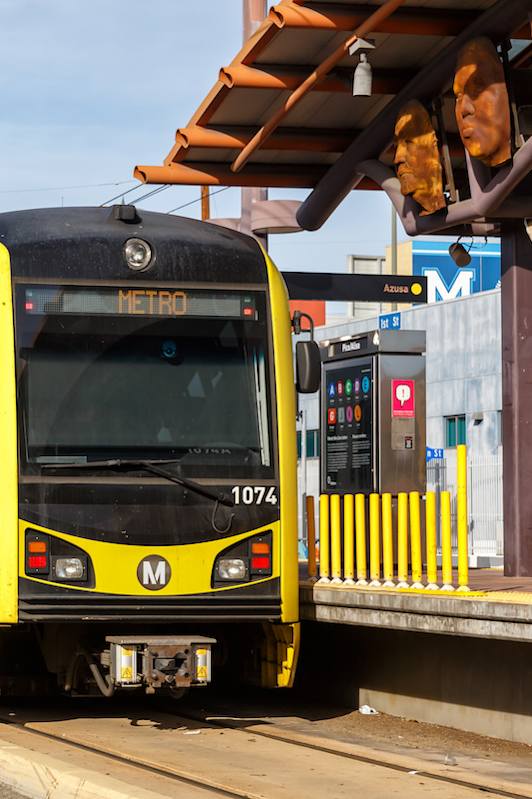 A yellow and black train with the number 1074 on the front is on a track.
