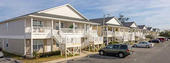 a row of houses with cars parked in front of them
