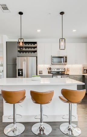 a large kitchen with a white island with four chairs