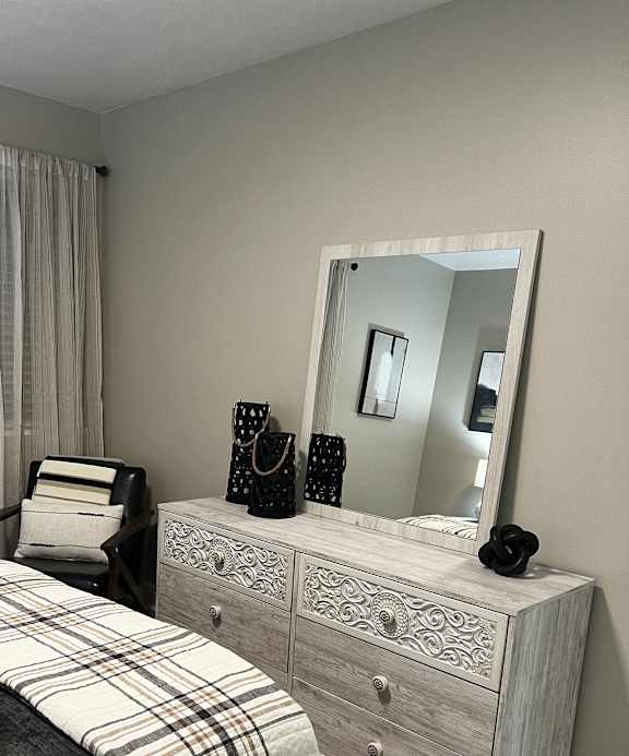 a bedroom with a bed and a mirror on the wall