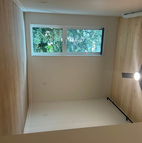 A room with a ceiling fan and a window.