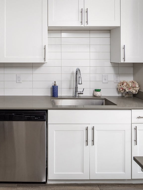 a white kitchen with stainless steel appliances and white cabinets
