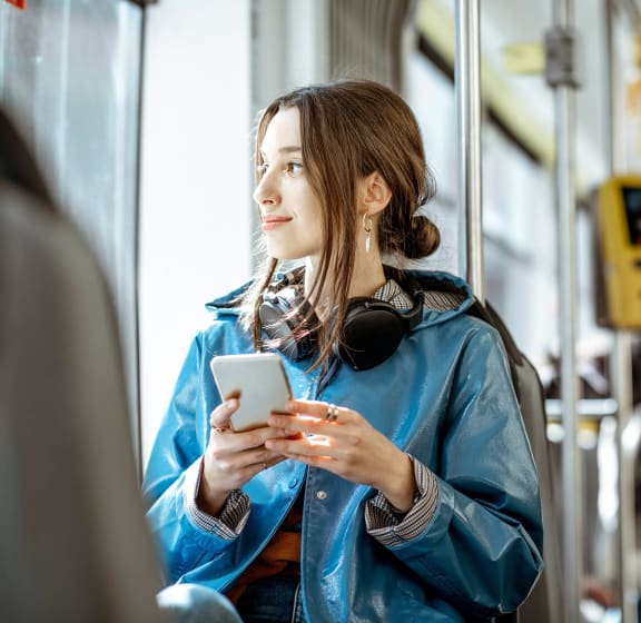 a woman on a subway train using her phone
