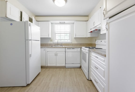 a white kitchen with white appliances and white cabinets