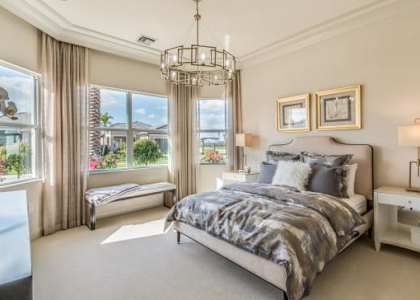 A bedroom with a large bed and a chandelier.
