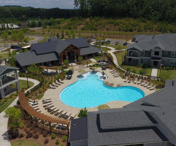 Drone shot view of community showing the resort style pool, leasing office and apartment buildings