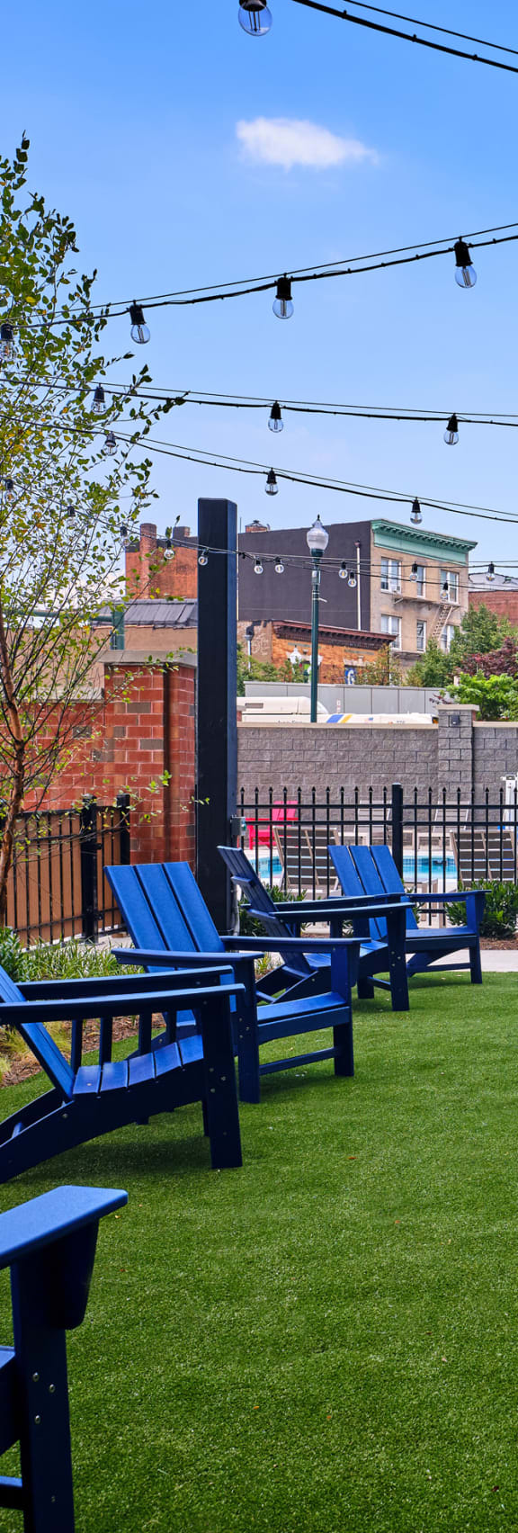 a courtyard with blue benches and chairs and a pool at Shearwood Station, New York