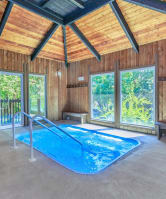 a large indoor pool with a wooden ceiling and large windows