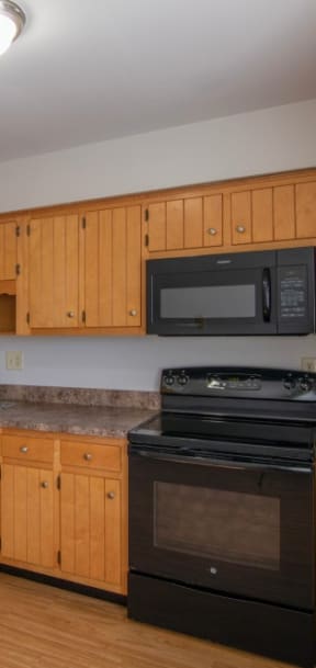 a kitchen with white cabinets and a black stove and refrigerator