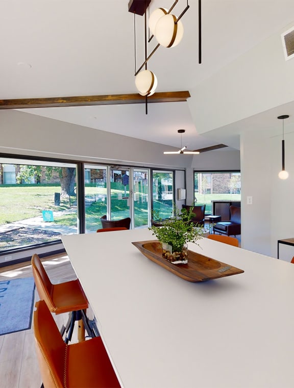 a dining room with a long white table and orange chairs