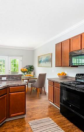 A kitchen with wooden cabinets and a black stove top oven.