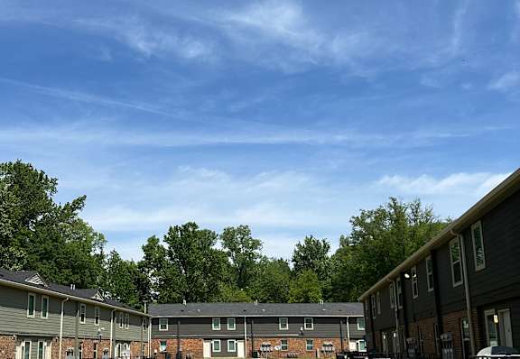 Apartment building with a green lawn in front of it.