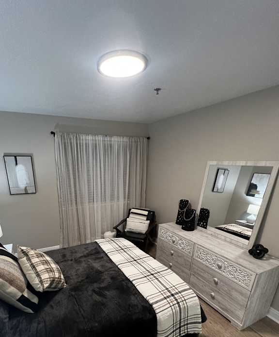 a loft bedroom with a bed and a desk and a mirror