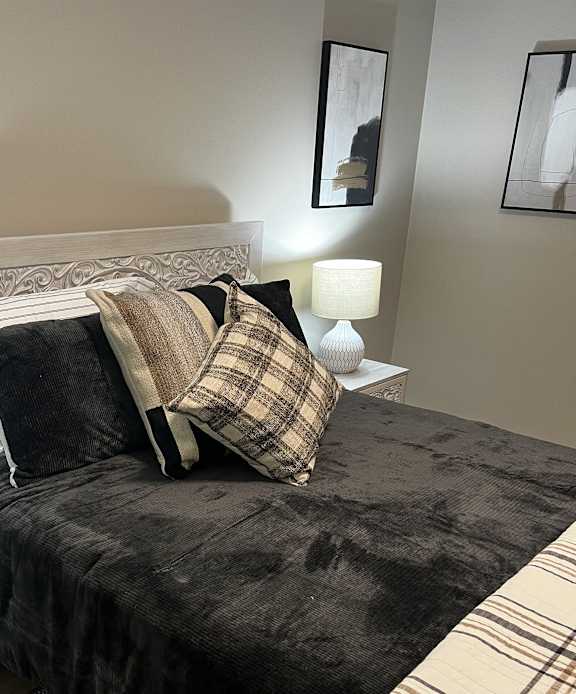 a bedroom with a bed with pillows and a blanket