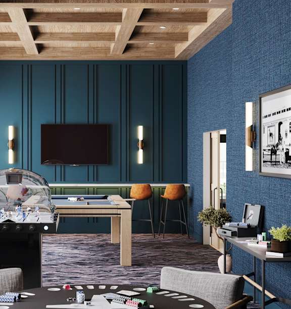 Game room with foosball table and lounge seating at Wildwood Lakeville Apartments, Lakeville, MN