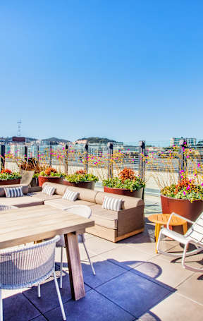 A patio with a table, chairs, and potted plants.at The Rise, San Francisco, 94103