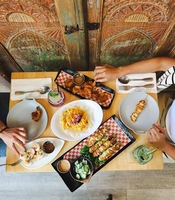 Two people eating at a table with food on it at Queen St East in Scarborough, ON