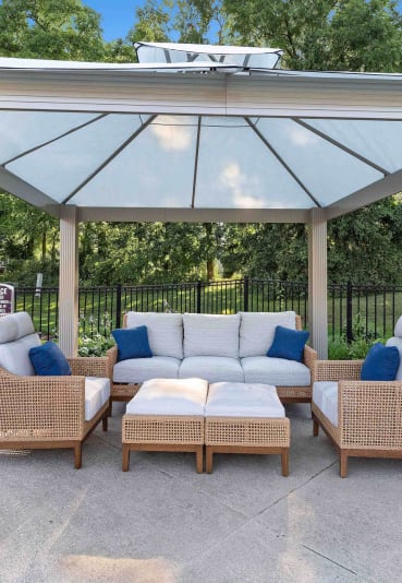 a pergola with a couch and chairs under it