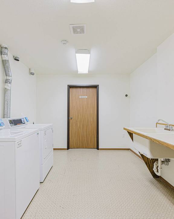 A laundry room with a washer and dryer and a sink.