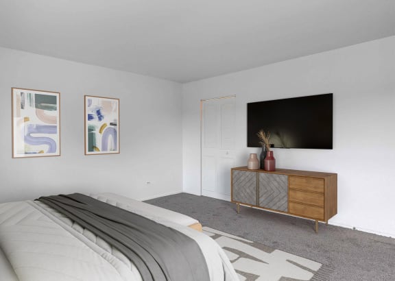 a bedroom with a large bed and a tv on the wall