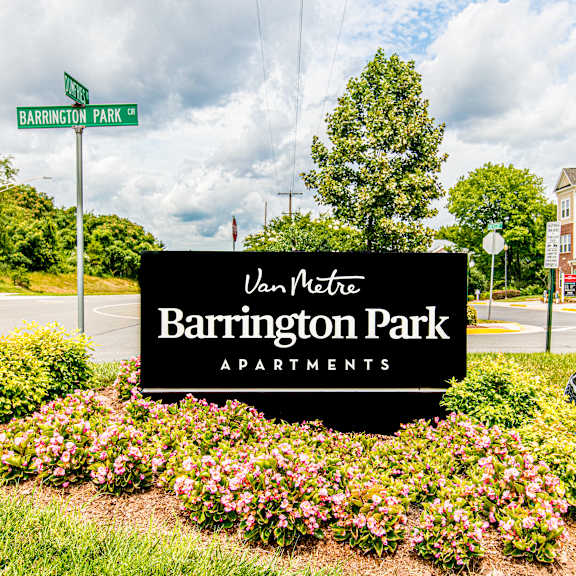 A bedroom with a bed, bench, and window. at Barrington Park Apartments, Manassas, Virginia
