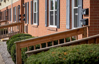 A row of houses with dark shutters and wooden railings.