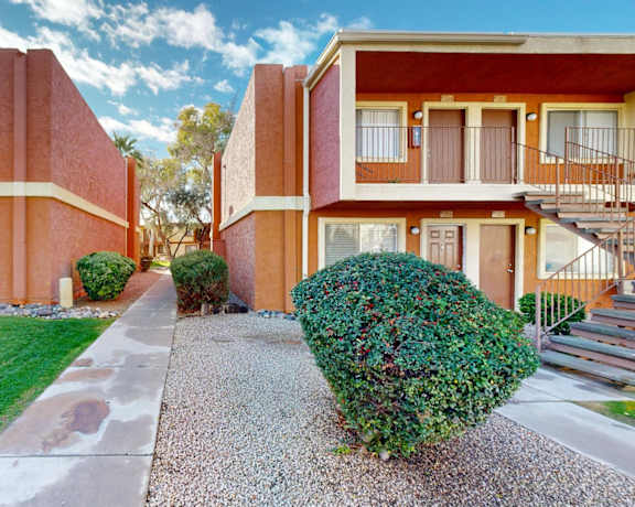 a sidewalk between two apartment buildings with a yard and grass at La Terraza, Phoenix, AZ, 85018