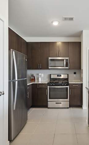 A kitchen with black cabinets and a checkered floor.