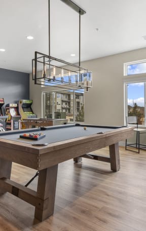 a living room with a wooden table and a kitchen in the background at Parkside at Littleton Village, Littleton, 80122