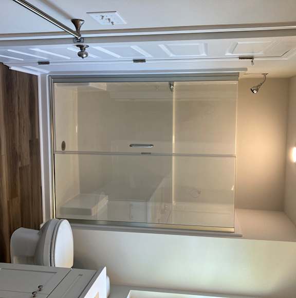 A bathroom with a glass shower door and a white sink.