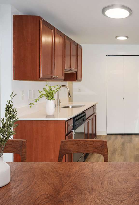 a living room with a leather couch and a kitchen with large windows