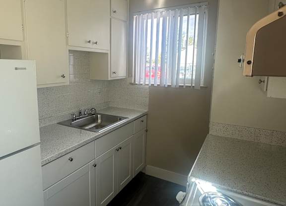 A white washing machine is in a small laundry room.