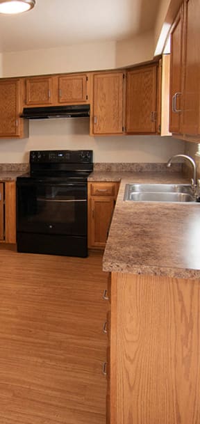 a kitchen with white cabinets and a black stove and refrigerator