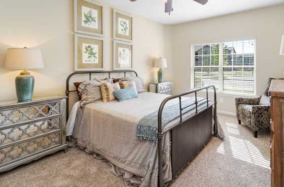 A bedroom with a bed, dresser, and mirror.