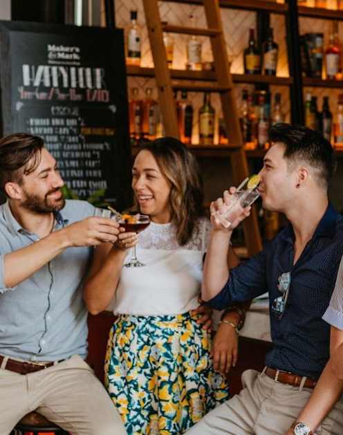 A group of people are socializing and drinking at a bar.