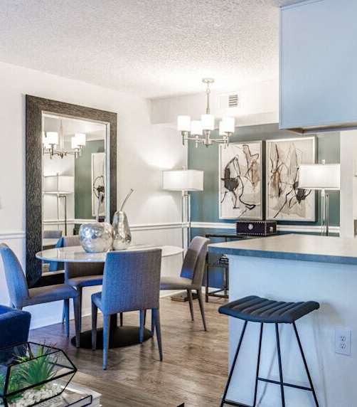 a kitchen and living room with a bar and stools
