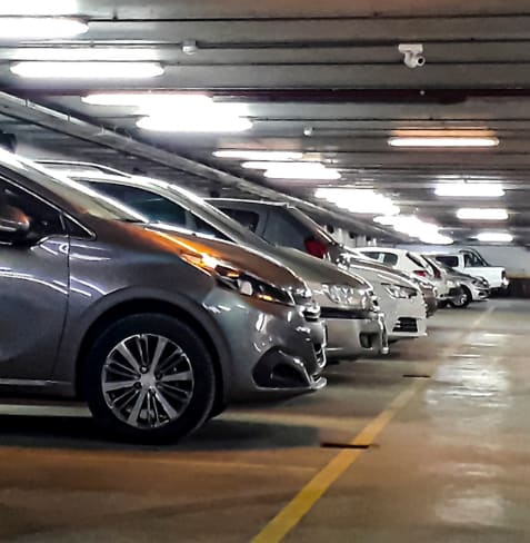 A parking garage with several cars parked.